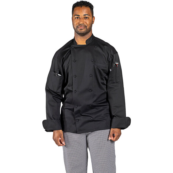 A man wearing a black Uncommon Chef Vigor Pro Vent long sleeve chef coat with mesh back.