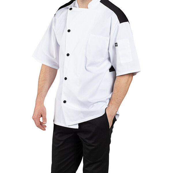 A man wearing a white Uncommon Chef Rogue Pro Vent chef coat.