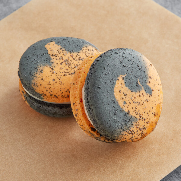 Two Macaron Centrale macarons with black and grey speckles.