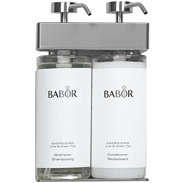 Two white oval bottles with black Babor labels in a white wall mounted dispenser.