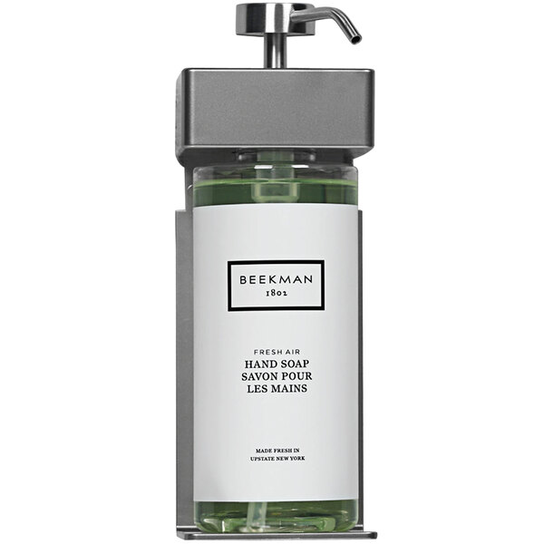A black Dispenser Amenities wall mounted soap dispenser with a white oval Beekman label.