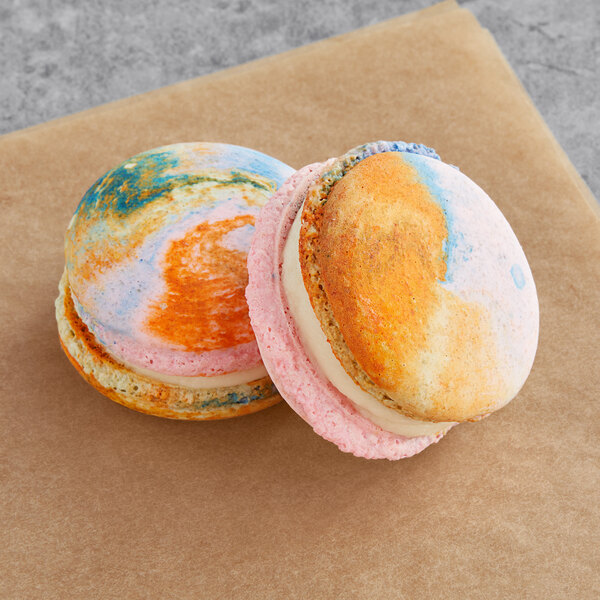 Two Macaron Centrale vegan agave macarons with colorful designs on them.