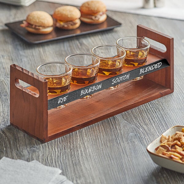 An Acopa wooden tray with four Acopa glass espresso cups filled with drinks.