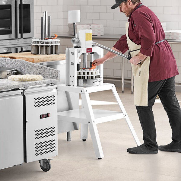 A man in a chef's hat uses an Estella manual dough divider.