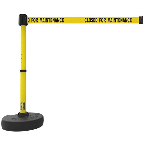 A yellow Banner Stakes retractable barrier tape with black text reading "Closed for Maintenance" and black rings.