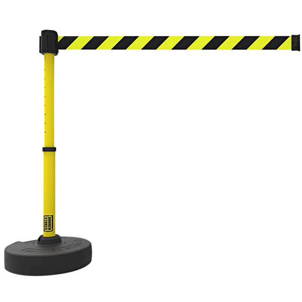 A yellow and black striped Banner Stakes PLUS retractable barrier pole with a black base.