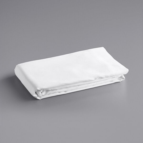 A white folded Oxford Super pillow case on a gray surface.