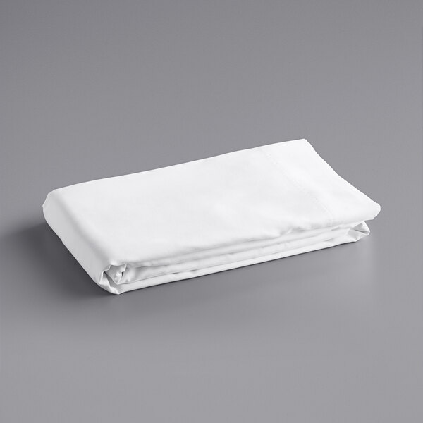 A folded white Oxford Super pillow case on a gray surface.
