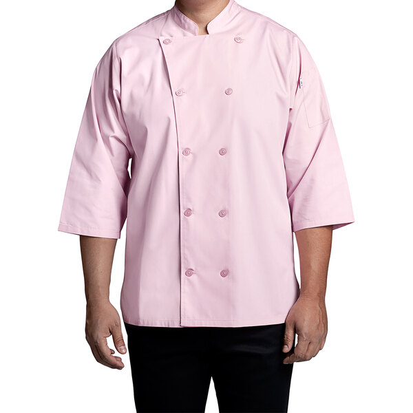A man wearing a pink Uncommon Chef 3/4 sleeve chef coat standing in a professional kitchen.