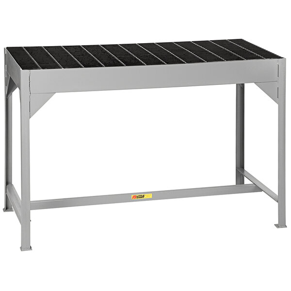 A grey metal Little Giant welding table with black steel grating.