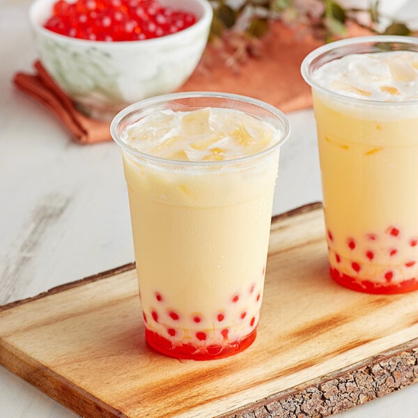A cup of Bossen pumpkin spice bubble tea with orange balls and ice.