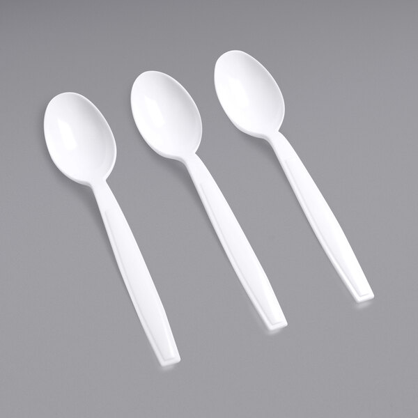 A close-up of three white Fineline Flairware plastic spoons.