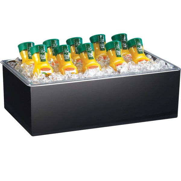 A black Cal-Mil ice housing container on a table with a clear pan of orange juice bottles inside.