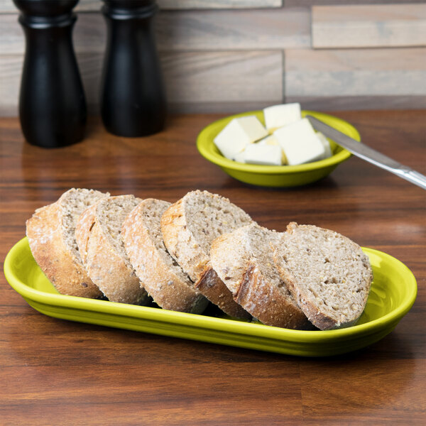 A Lemongrass oval china bread tray with sliced bread on it.