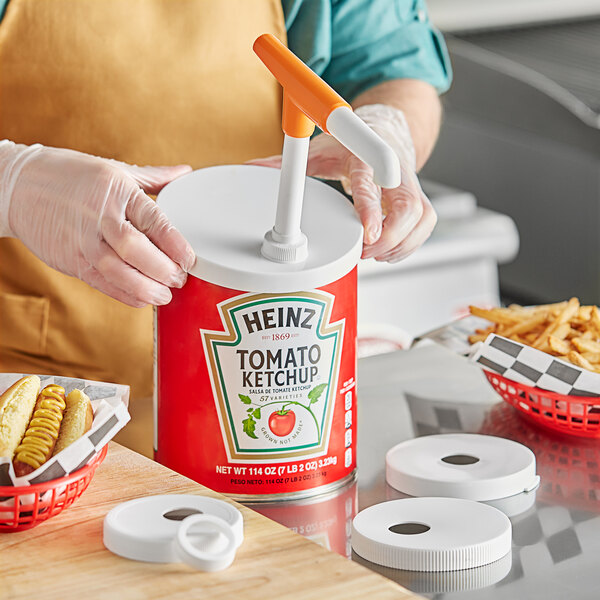 A hand using a Choice condiment pump to dispense ketchup into a white circular container.