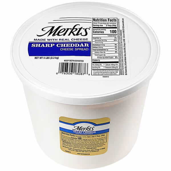 A container of Merkts Sharp Cheddar Cheese Spread on a counter.