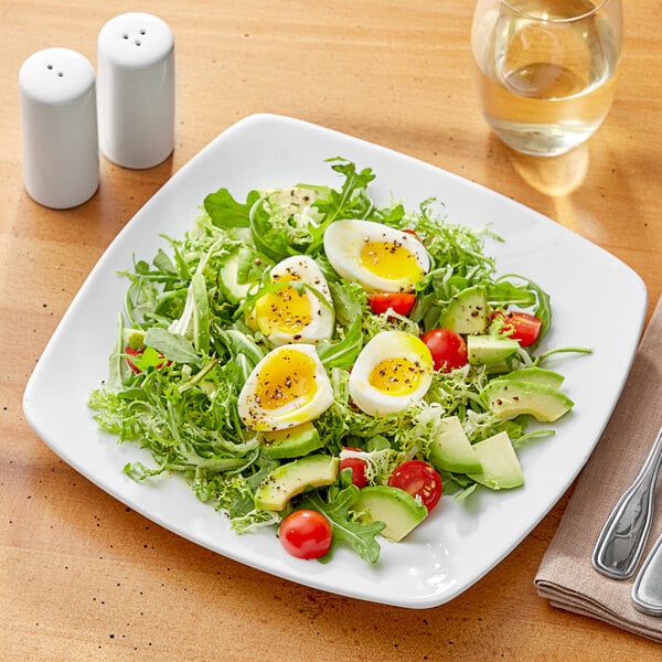 A white Acopa square coupe plate with a salad and hard boiled eggs.