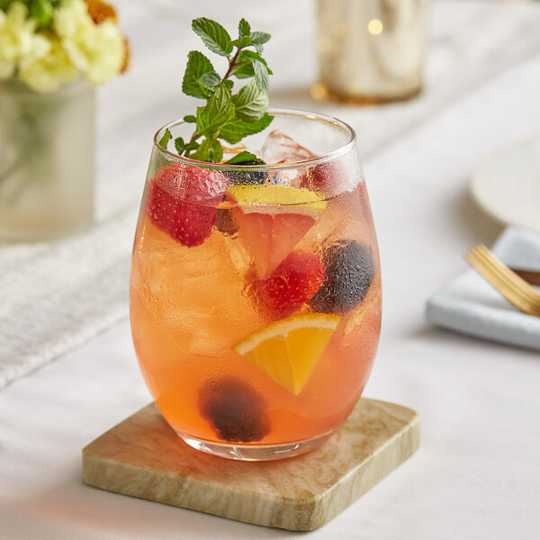A stemless Acopa wine glass filled with a fruity drink and garnished with berries and mint.