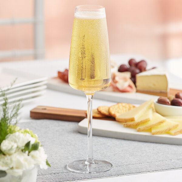 An Acopa Piatta flute glass of champagne on a table.