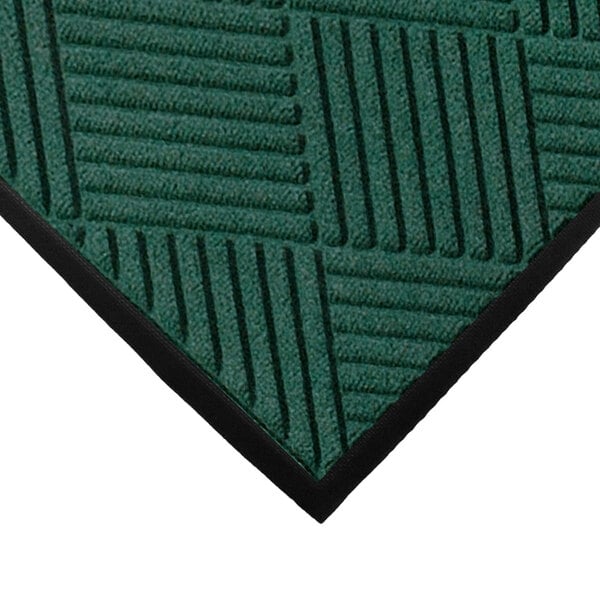 A green WaterHog entrance mat with black rubber borders and diamond pattern.
