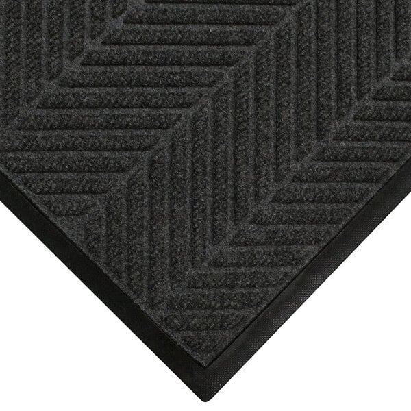 A close-up of a black WaterHog mat with a chevron patterned border.