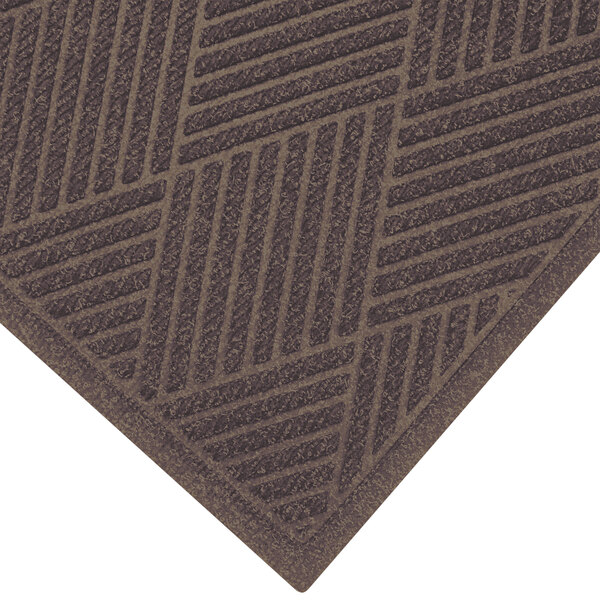 A brown M+A Matting WaterHog mat with a patterned border.