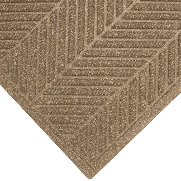 A khaki WaterHog carpet mat with a chevron pattern.
