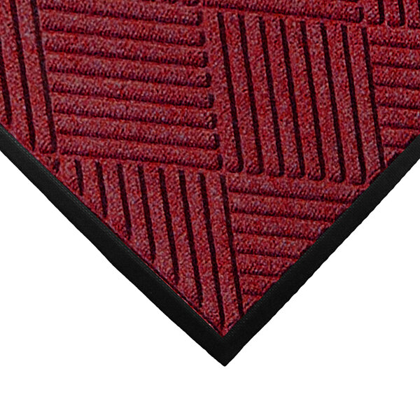 A red WaterHog mat with black stripes and a rubber border.