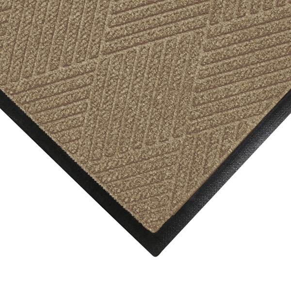 A khaki WaterHog carpet mat with black rubber trim.