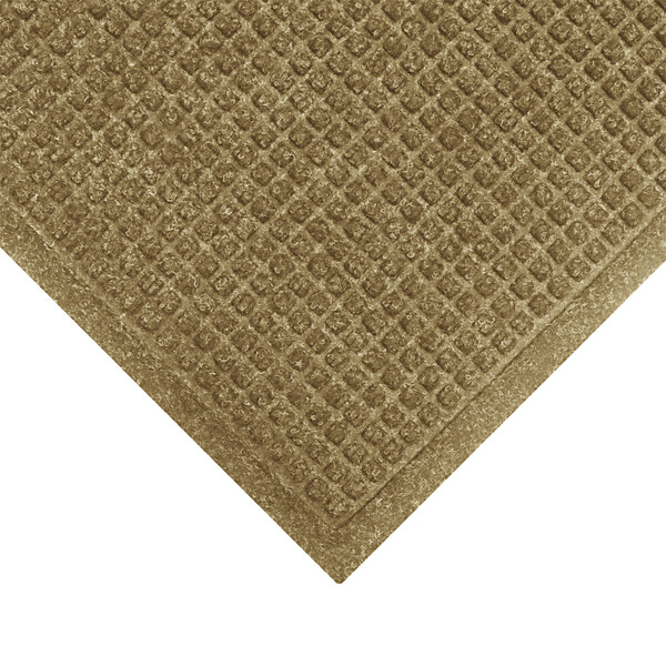 A brown M+A Matting WaterHog mat with a diamond patterned border.