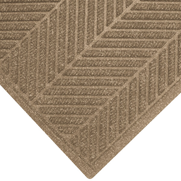 A khaki WaterHog mat with a chevron patterned border.