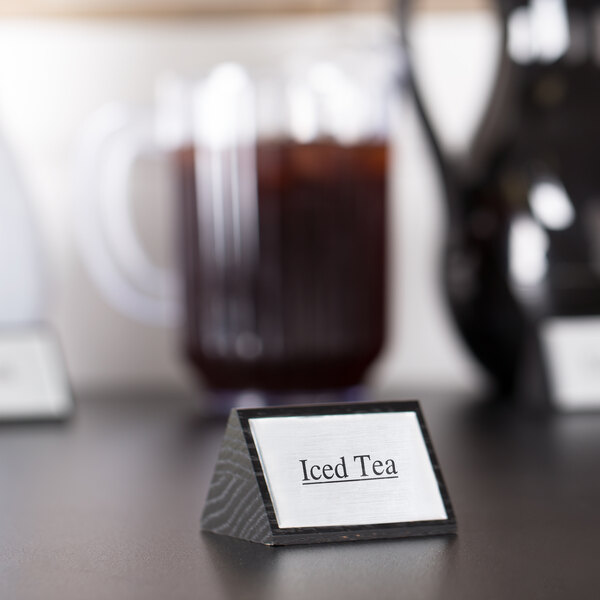 A close-up of a black wood sign with the word "Iced Tea" on it.