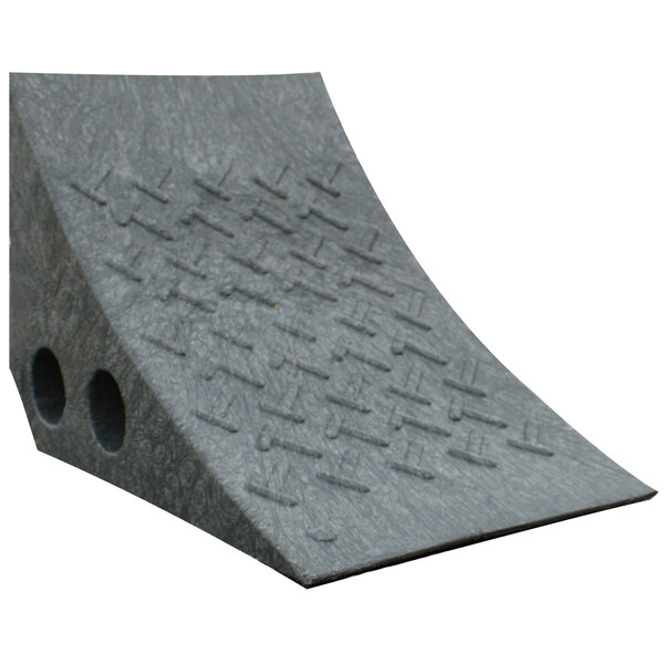 A grey plastic wheel chock with holes in it.