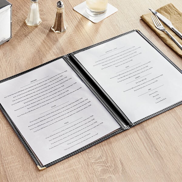 A black Choice menu cover with four pages on a table with a menu inside.