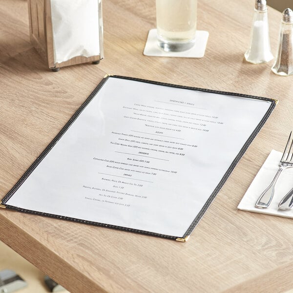 A black 2-view single pocket menu cover on a table in a brunch café.