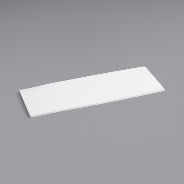 A white rectangular insulation panel on a gray surface.