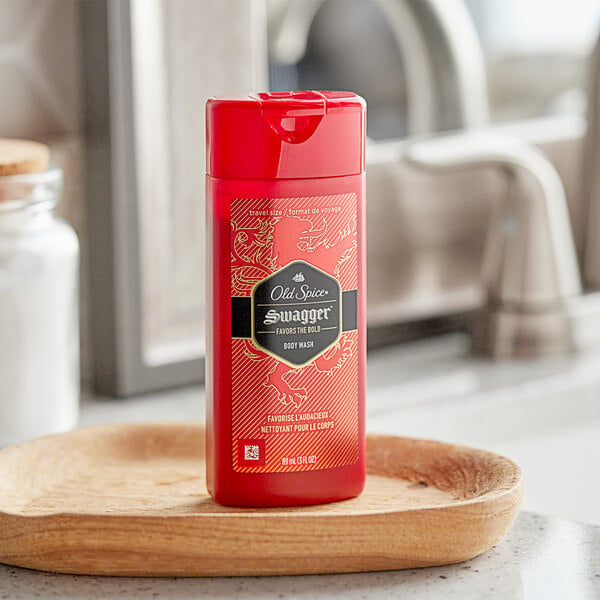 A red bottle of Old Spice Swagger Men's Body Wash on a wooden counter.