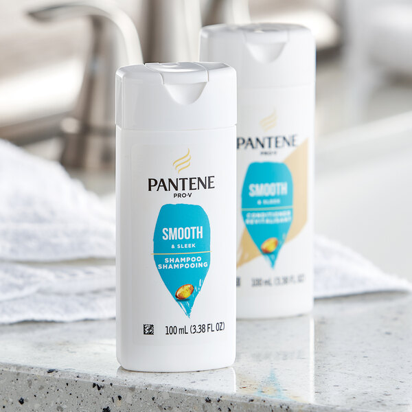 Two Pantene Pro-V Smooth and Sleek shampoo bottles on a counter.