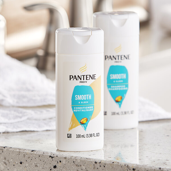 A group of Pantene Pro-V Smooth and Sleek conditioner bottles on a counter.