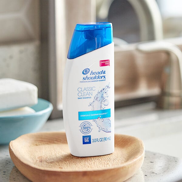 A bottle of Head & Shoulders Classic Clean shampoo on a wooden dish.