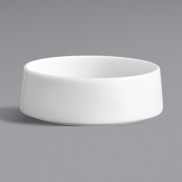 A Oneida Scandi bright white porcelain sauce dish with a raised rim on a white background.
