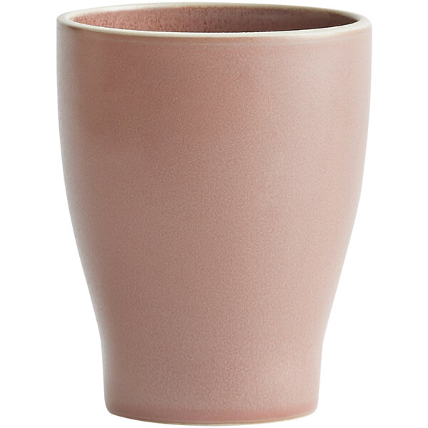 A close-up of a pink Oneida Moira stoneware tumbler with a white rim.