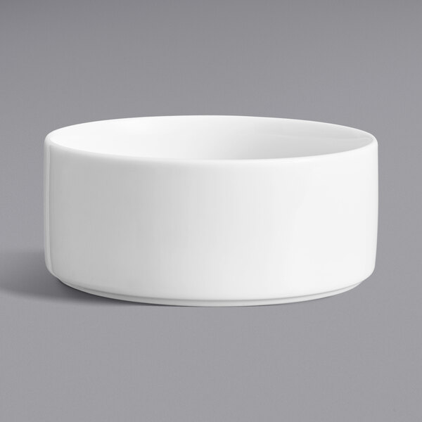 A Oneida Scandi bright white porcelain bowl with a raised rim on a gray surface.