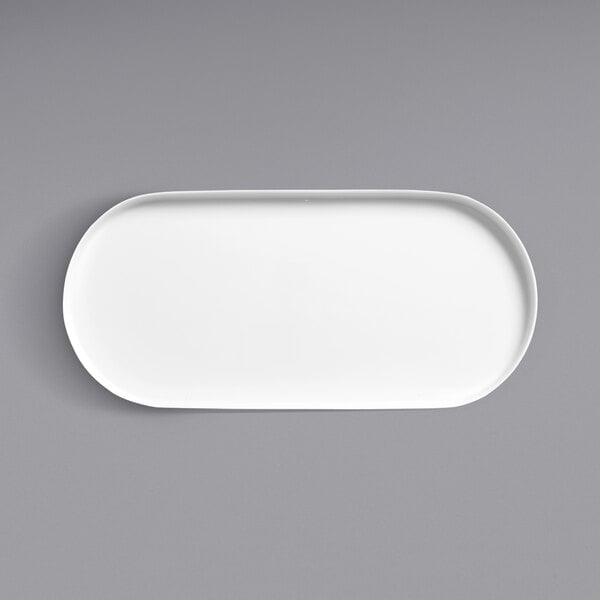 A white oval platter with a raised rim on a white background.
