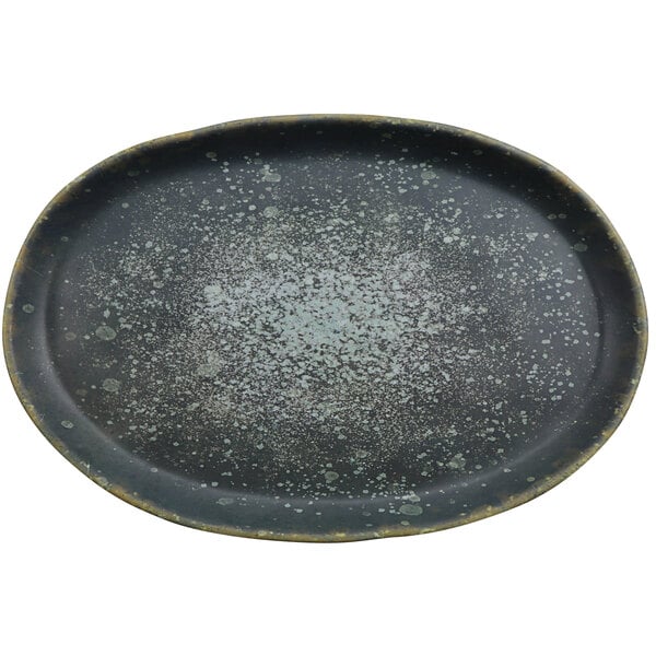 A black oval plate with gray and green specks.