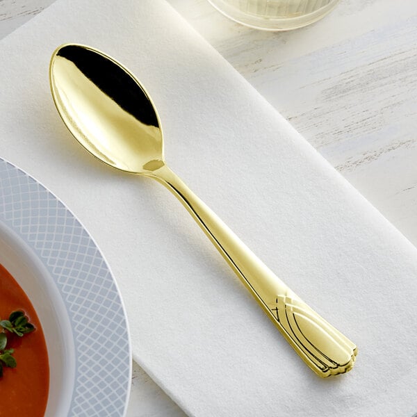 A Visions heavy weight gold plastic spoon on a white napkin.