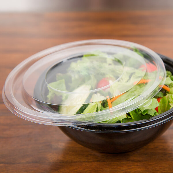 A bowl of salad with a Sabert clear lid.