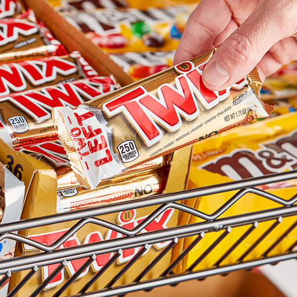 A person holding a TWIX® chocolate cookie bar.