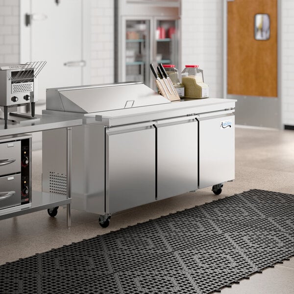 An Avantco stainless steel refrigerated sandwich prep table on a large counter.
