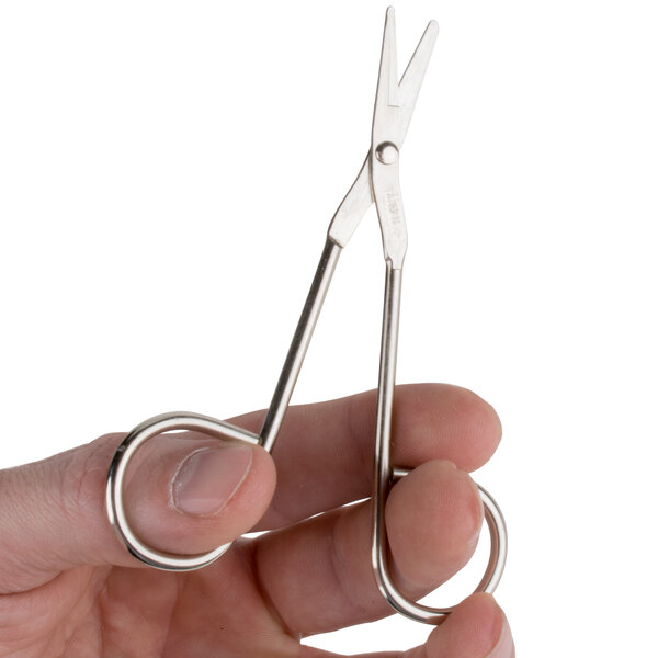 A close-up of a person's hand holding a pair of Medique wire scissors.
